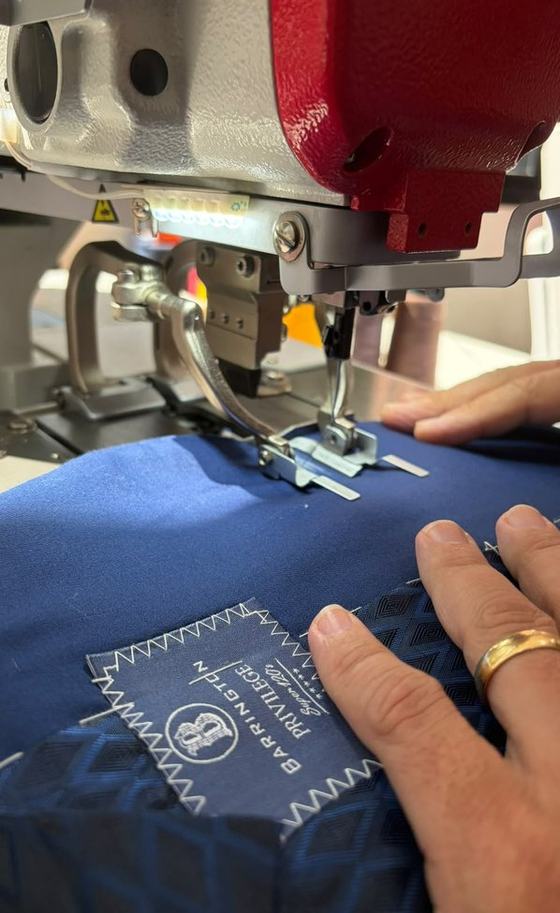 Mãos conduzindo o tecido na máquina de costura